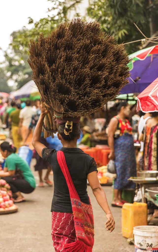 a women carrying A pile of straw