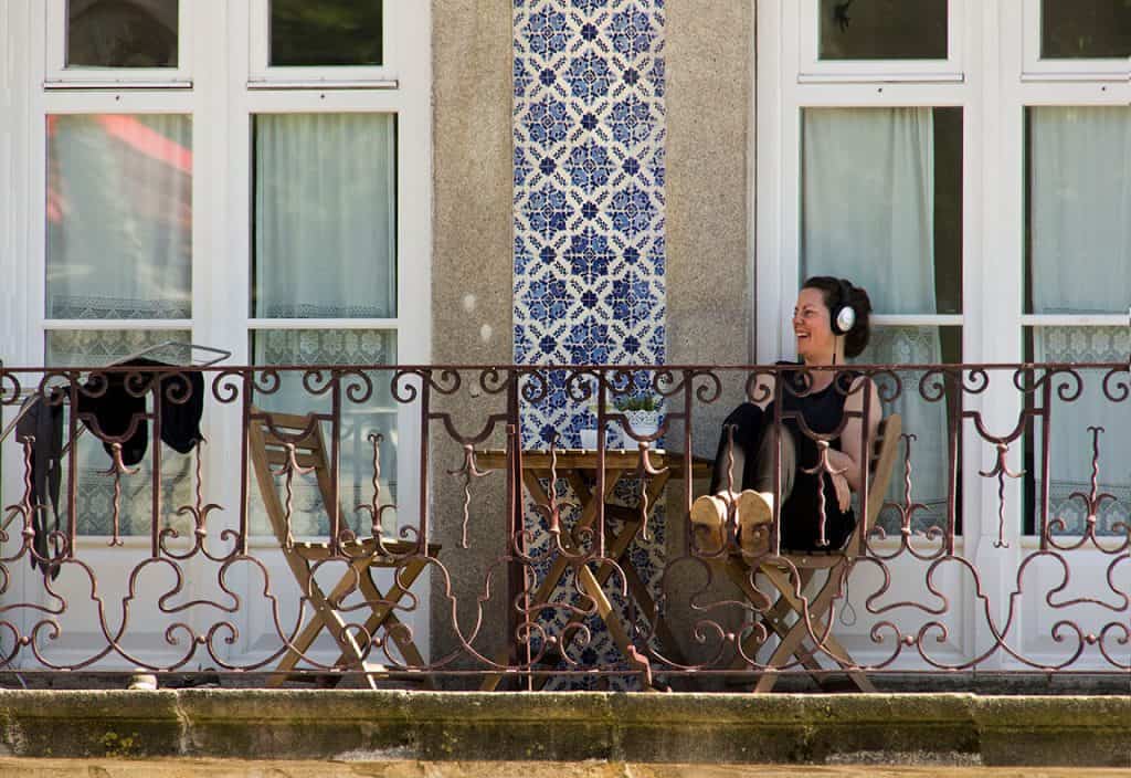 a women sitting on a balcony in Porto