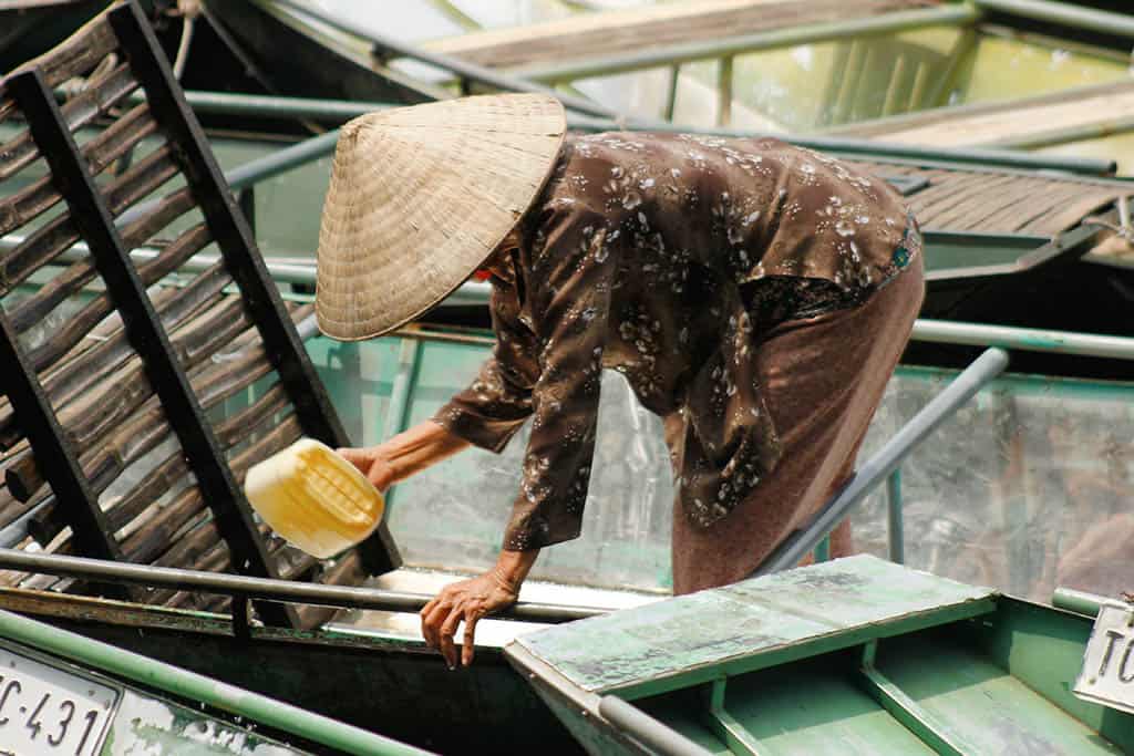 Vietnamese woman cleaning her boat