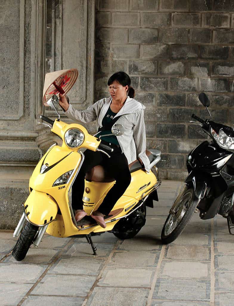 woman sitting on a yellow scooter Vietnam