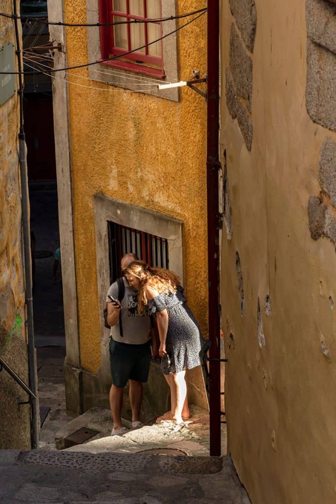 a couple taking a selfie in the barredo stairs in Porto