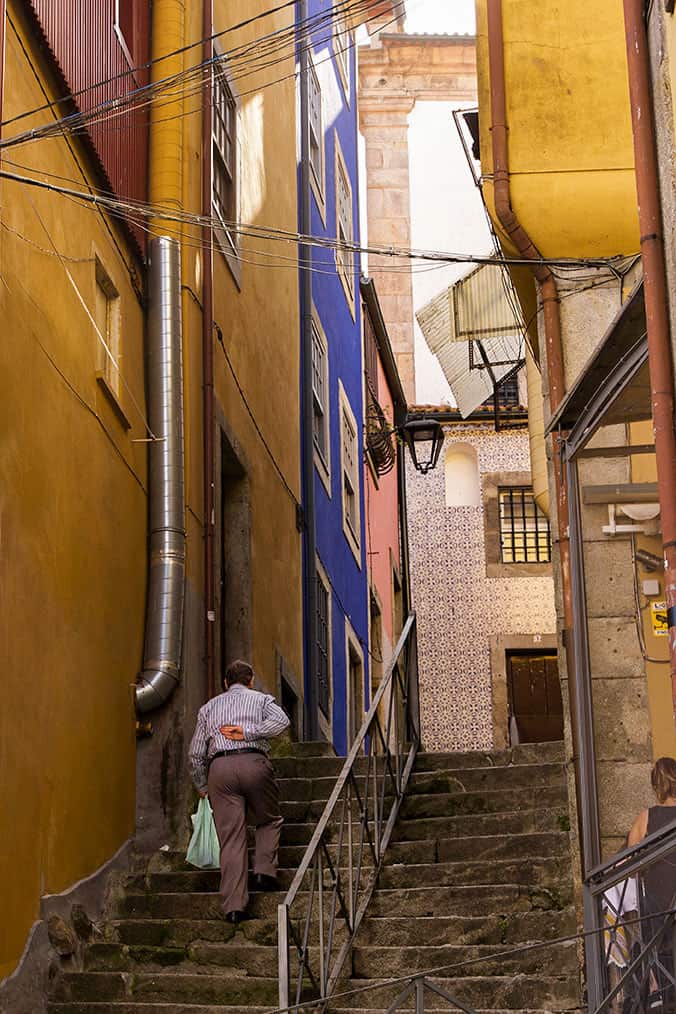 A man walking up the stairs in the colorful Ribeira neighborhood in Porto