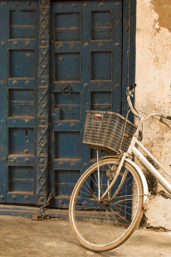 Bicycle leaning on a blue wooden door