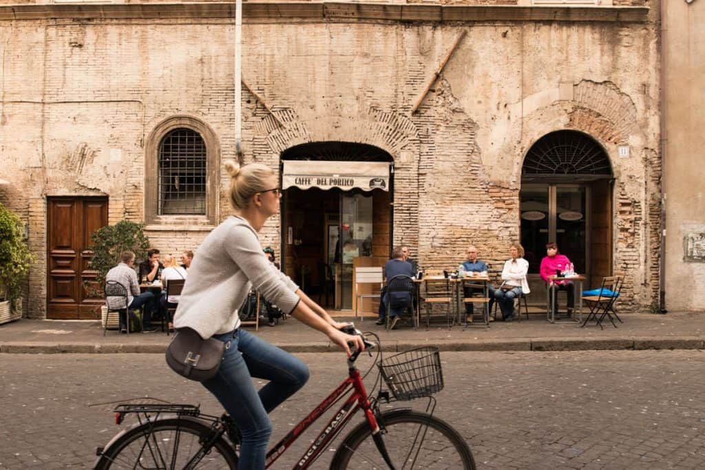 a women riding a bike in the Jewish neighborhood in Rome