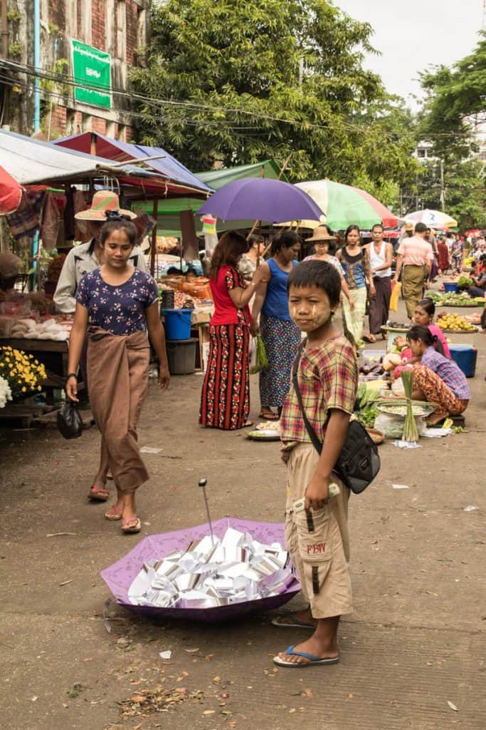 Burmese kid in the middle of a market