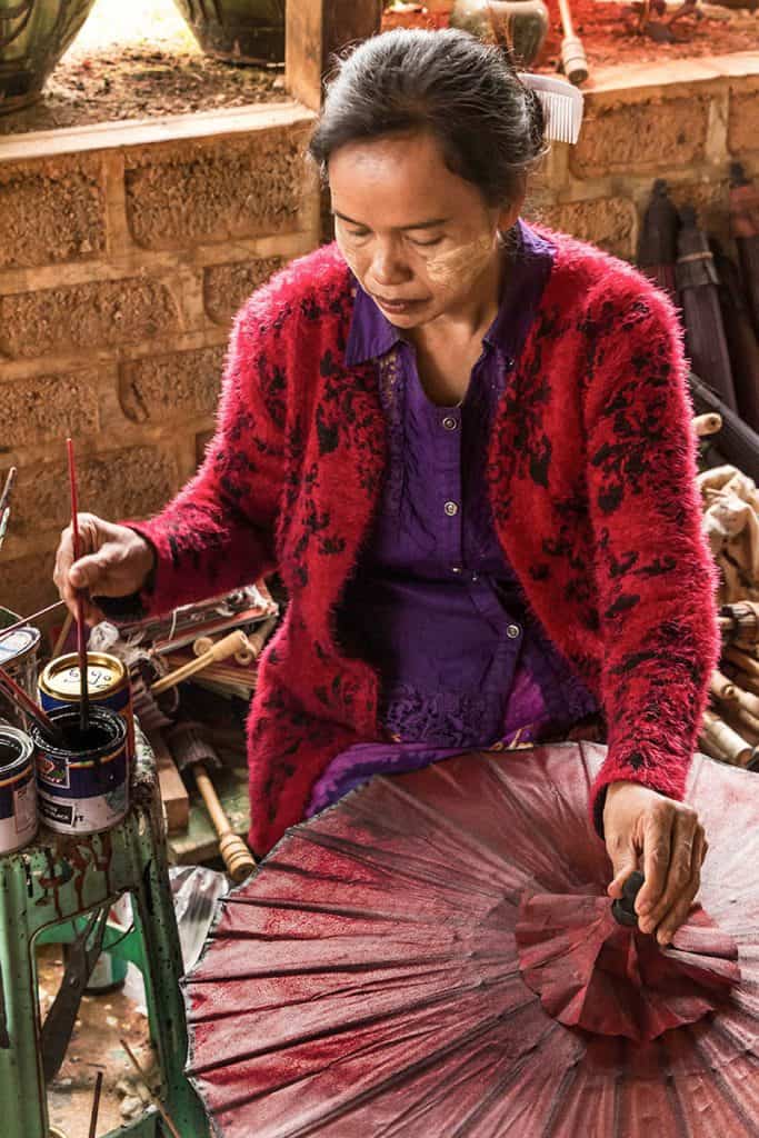 a woman decorating a paper umbrella