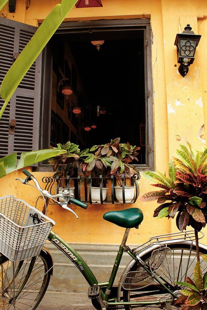 bikes leaning on a yellow wall