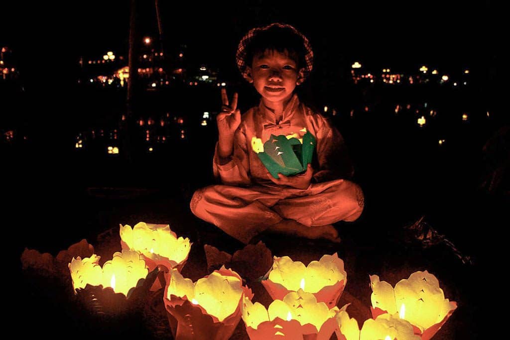 boy selling floating candles at night