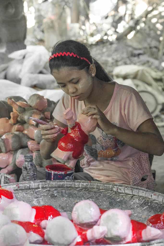 a girl making paper mache toys.