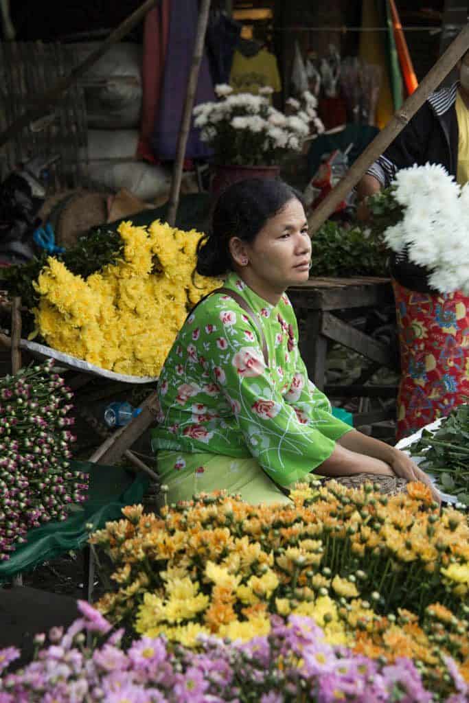 woman sitting in the middle of flowers