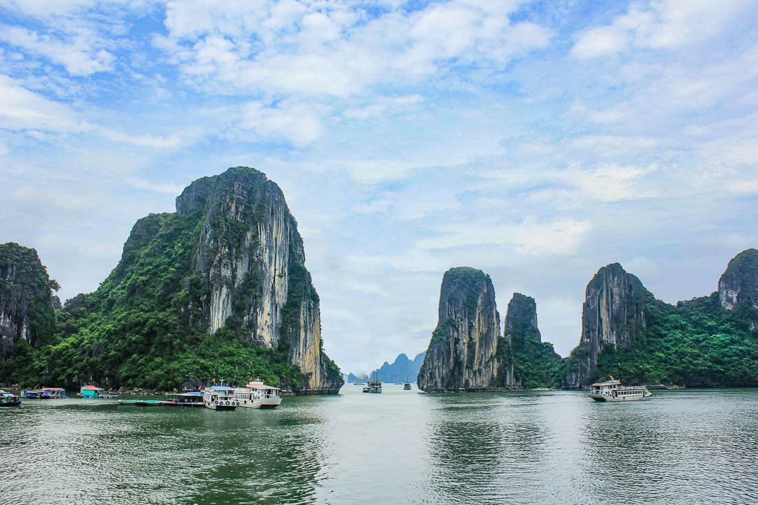 Boats among the tall cliffs of Halong Bay