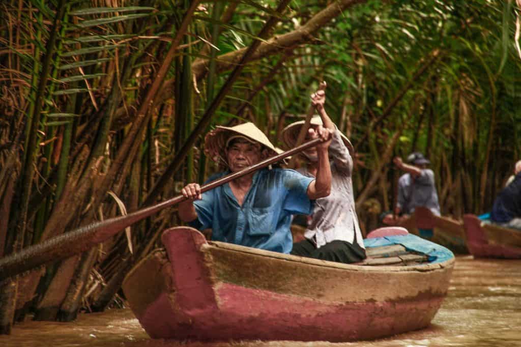 man and woman rowing a boat in Mekong Delta