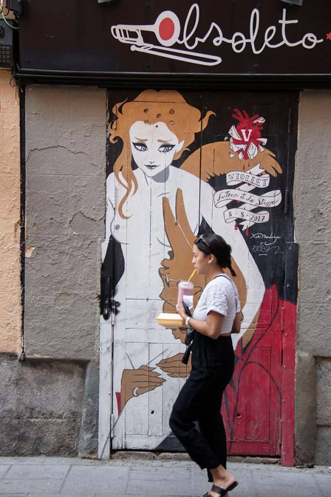 a woman walking in one of madrid's colorful streets