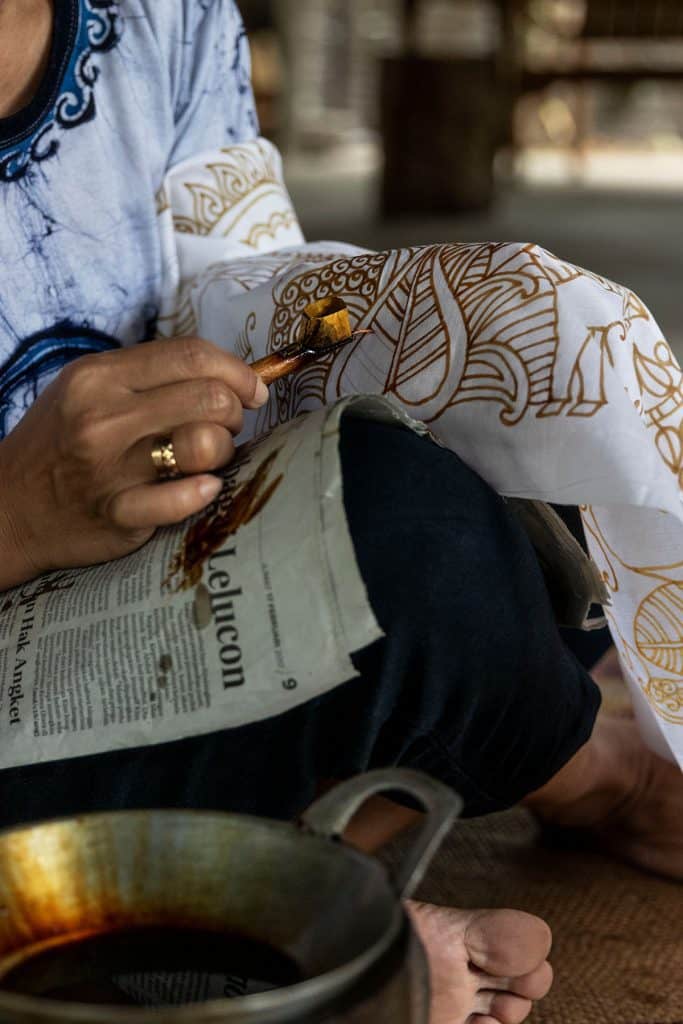 a woman making a batik fabric