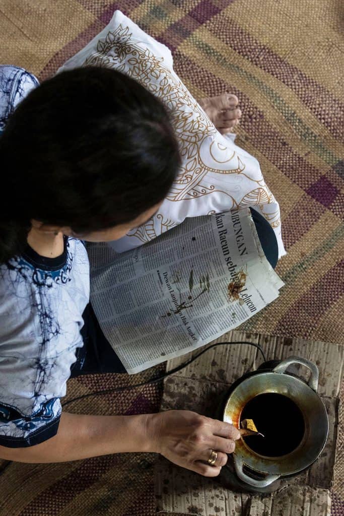 a woman making a batik fabric