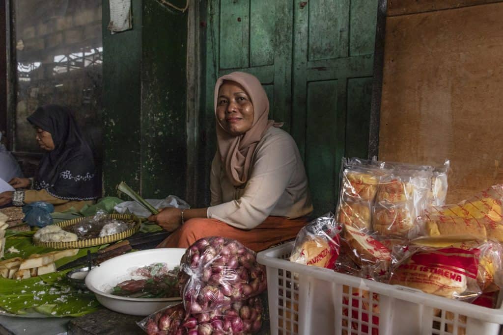 a woman selling food in a morning market