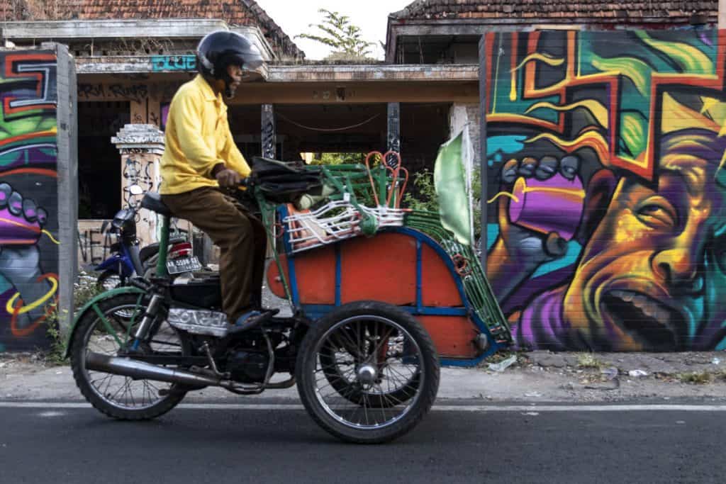 a man on a tuk tuk in yogyakarta streets