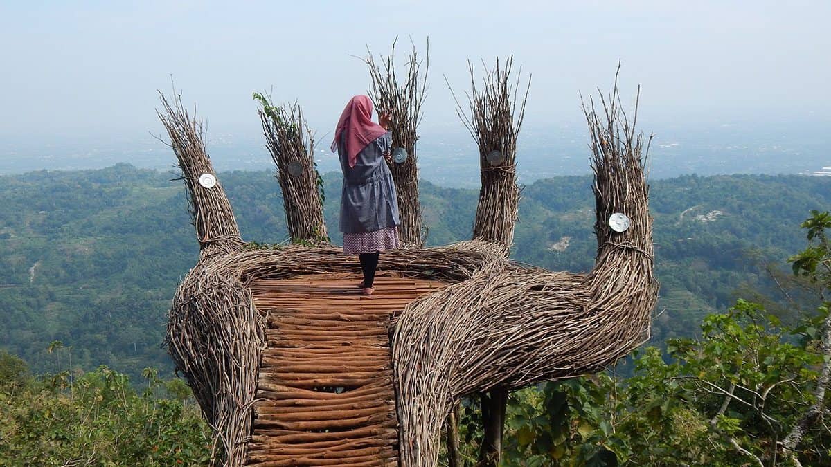 A woman posing in a elfie spot above a beautiful view