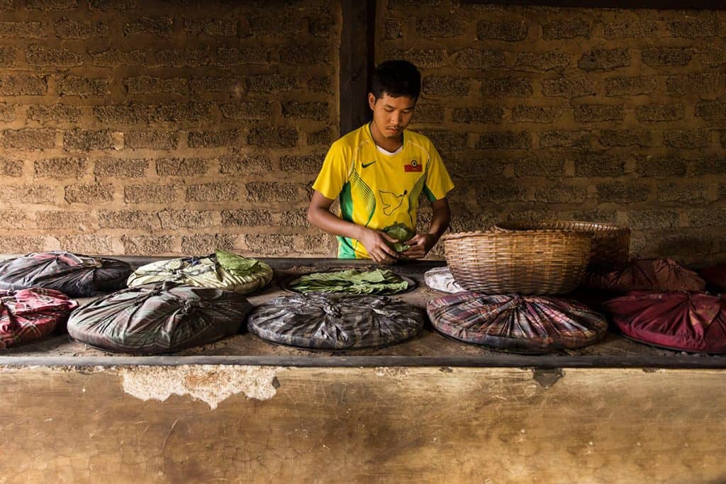 a Burmese man drying leaves for handmade cigars in Myanmar