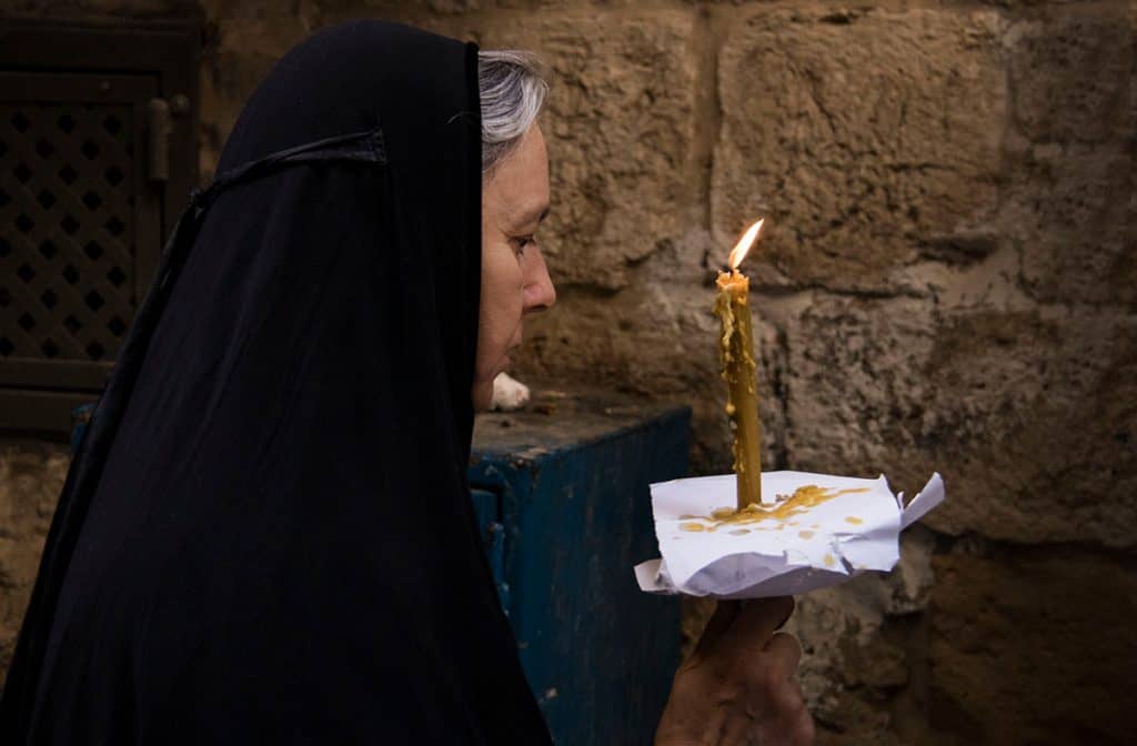 A nun holding a candle in Jerusalem