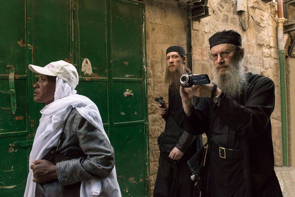 Priests filming the Good Friday procession in Jerusalem
