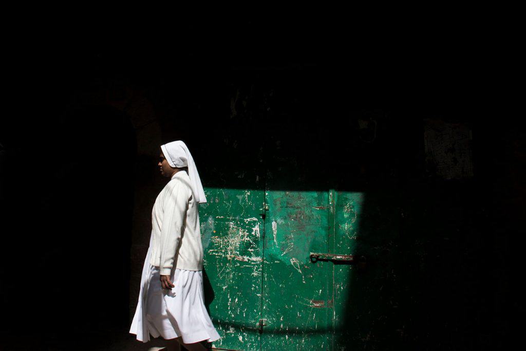 Nun walking in Jerusalem alleys
