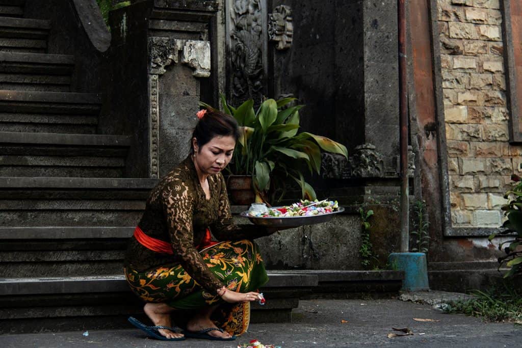 a Balinese woman in front of a local temple