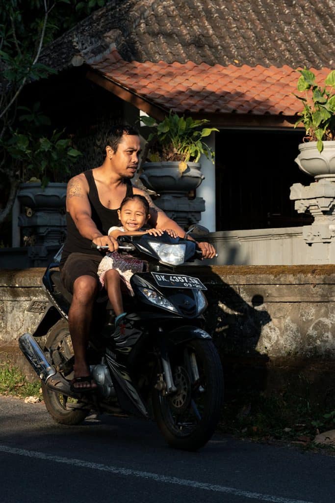 father and his daughter riding a motorbike in Bali