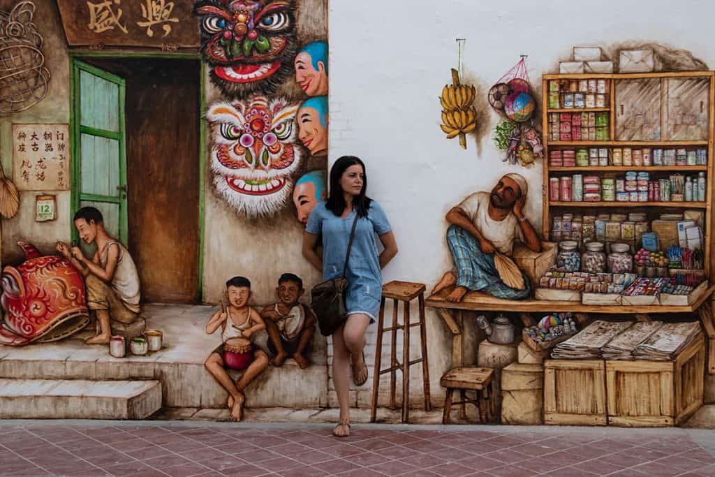 a woman standing in front the colorful murals in Chinatown Singapore