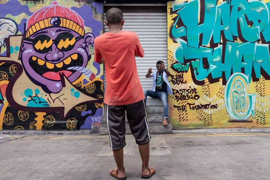 tourists taking a picture in front of the street art in Singapore