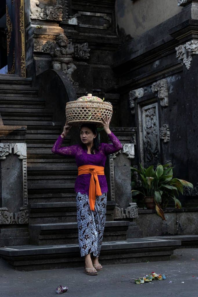 a Balinese woman in front of a local temple