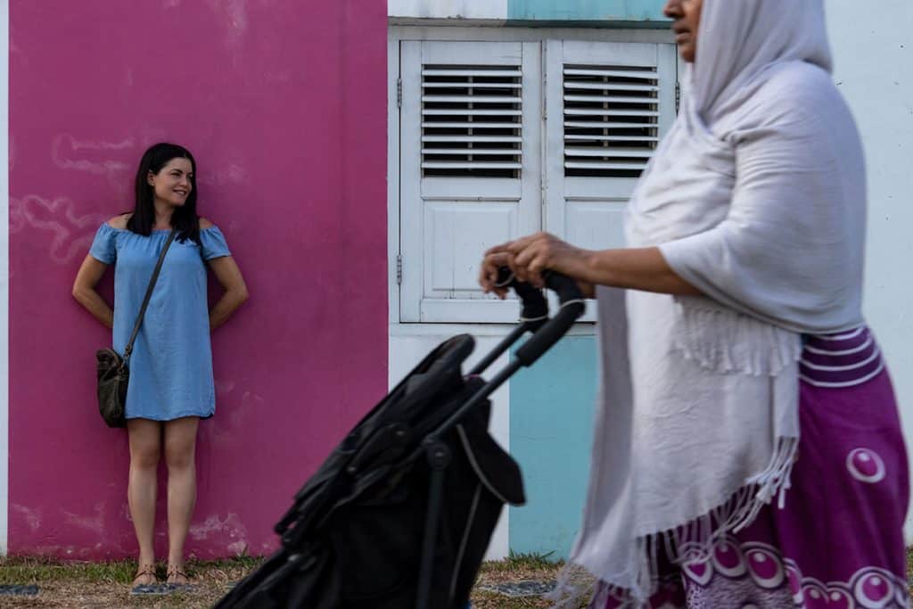 a woman standing in front of a pink wall in Singapore