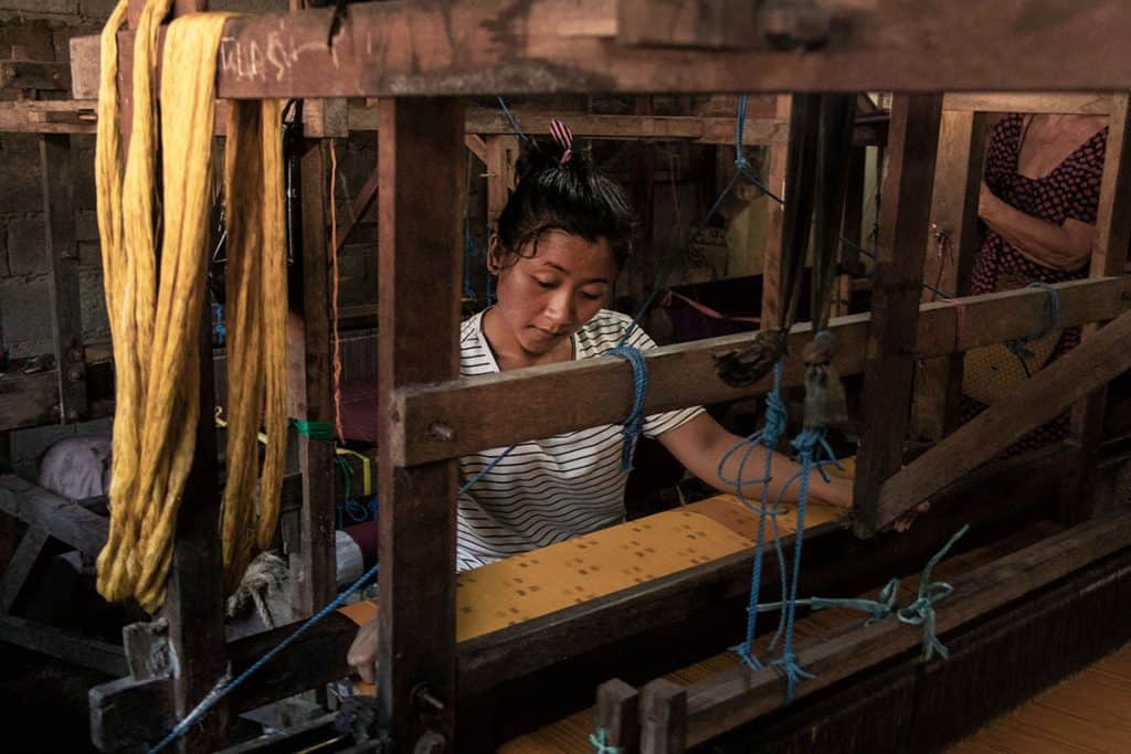 a girl weaving in one of Bali's factories in Sidemen Valley