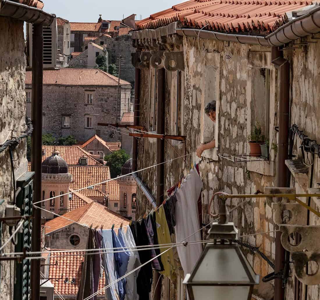 A woman hanging laundry at Dubrovnik's side streets