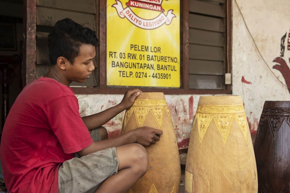 A boy making a Traditional drumsin Java, Indonesia