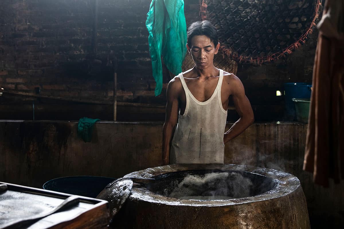 A man producing Tofu in a alocal factory in Indonesia