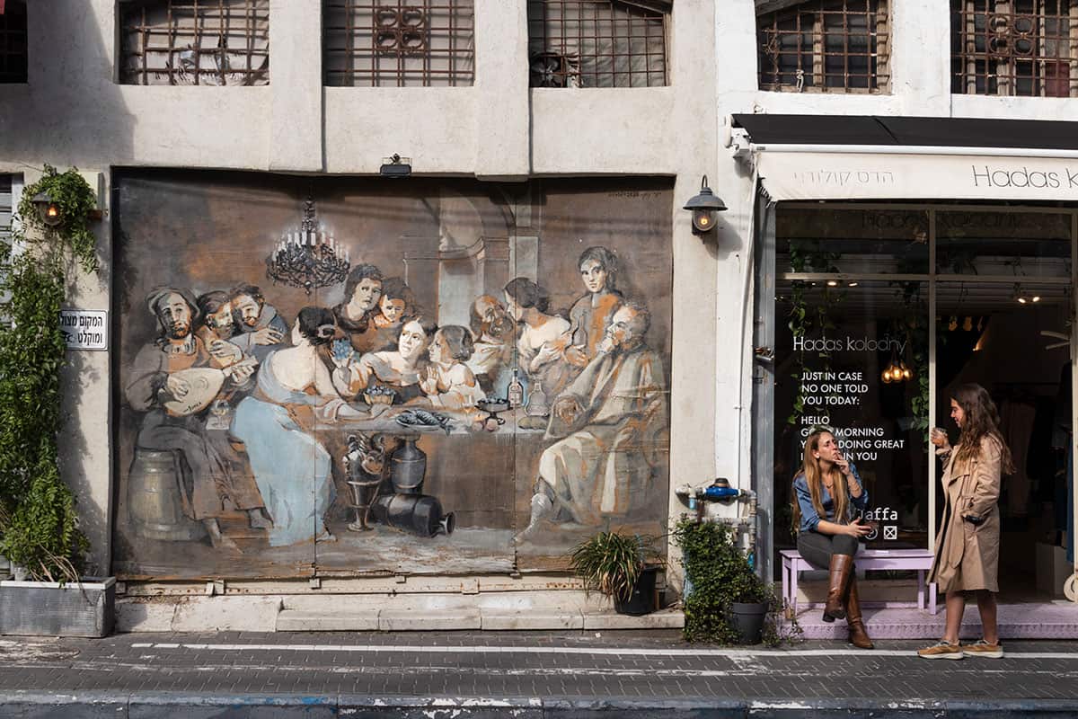 Two girls next to a beautiful Street art in jaffa TLV